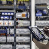 man electrical technician working switchboard with fuses 2 scaled